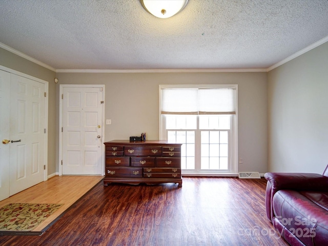 living area with dark hardwood / wood-style flooring, crown molding, and a textured ceiling