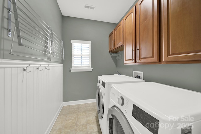 laundry room with baseboards, cabinet space, visible vents, and washer and clothes dryer