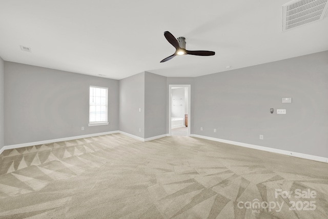 empty room with visible vents, baseboards, and light colored carpet