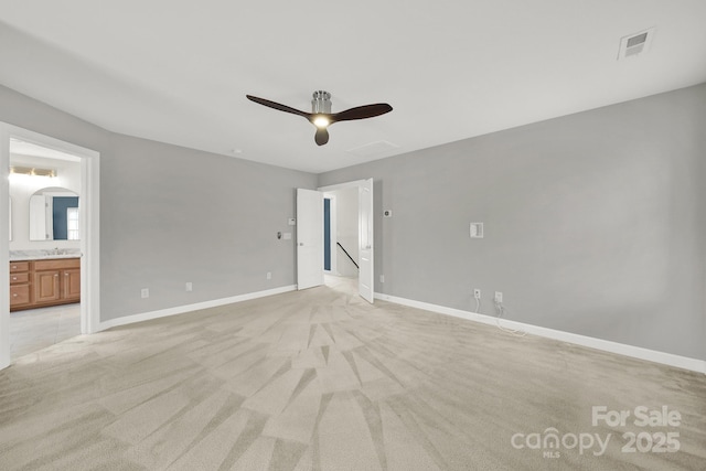 unfurnished bedroom with visible vents, baseboards, ensuite bath, arched walkways, and light carpet