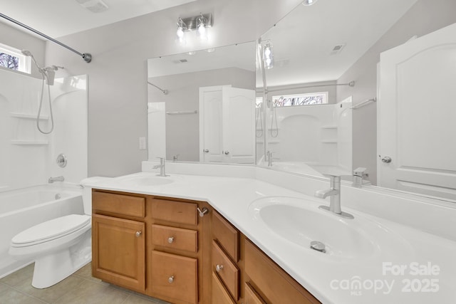 full bathroom with double vanity, toilet, shower / bathing tub combination, and a sink