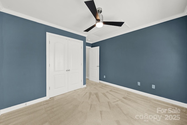 unfurnished bedroom featuring a closet, baseboards, ornamental molding, and carpet flooring