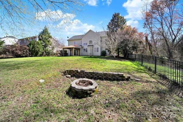 view of yard with a fire pit and a fenced backyard