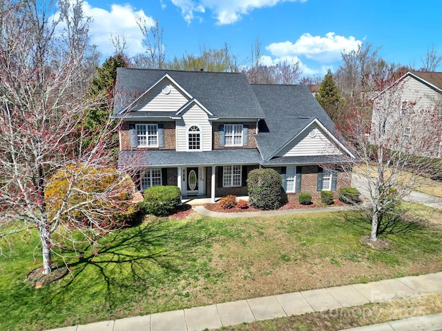 traditional home featuring brick siding and a front yard