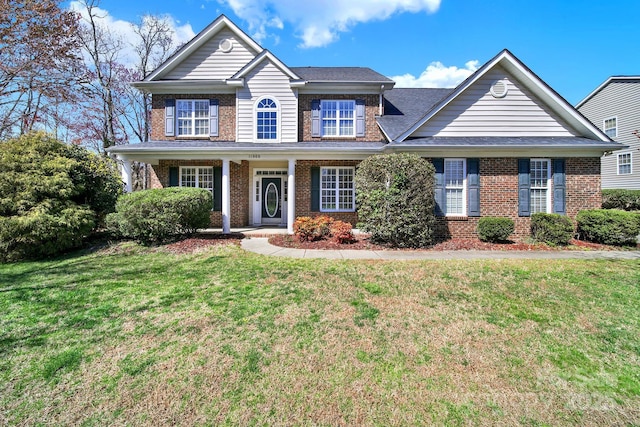 traditional-style house with a front yard and brick siding