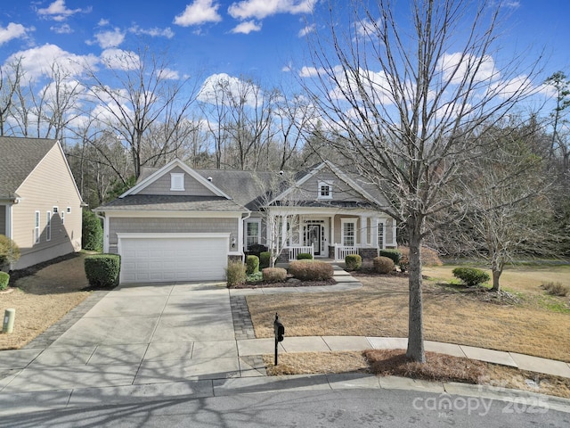 view of front of property featuring driveway, a porch, and an attached garage