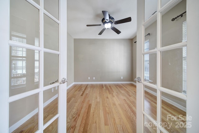 spare room with french doors, plenty of natural light, light wood-style flooring, and baseboards