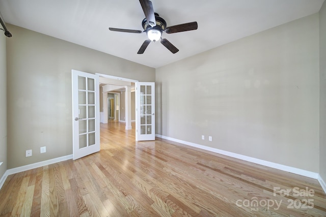 spare room featuring french doors, baseboards, ceiling fan, and light wood finished floors