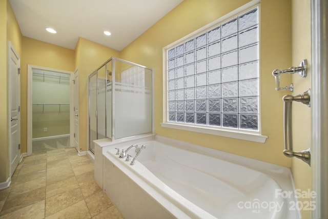 full bath featuring a stall shower, a garden tub, a walk in closet, and recessed lighting