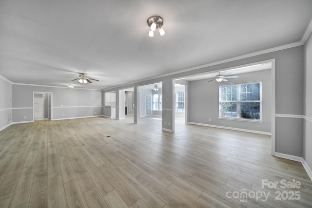 unfurnished living room featuring light wood-style floors, ornamental molding, baseboards, and ceiling fan