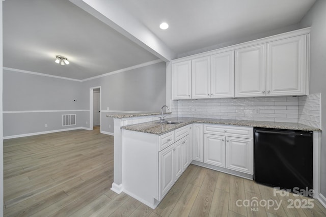 kitchen featuring a peninsula, a sink, white cabinets, light wood-style floors, and dishwasher