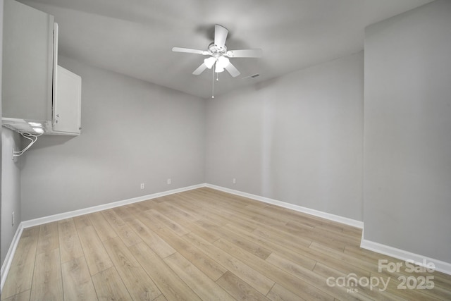 empty room featuring light wood-style flooring, visible vents, baseboards, and ceiling fan