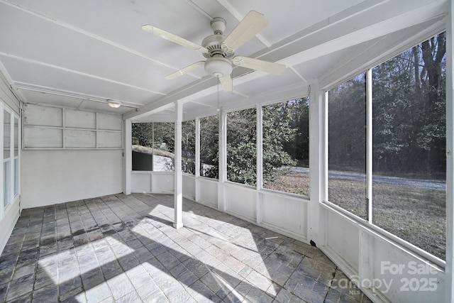 unfurnished sunroom featuring a ceiling fan