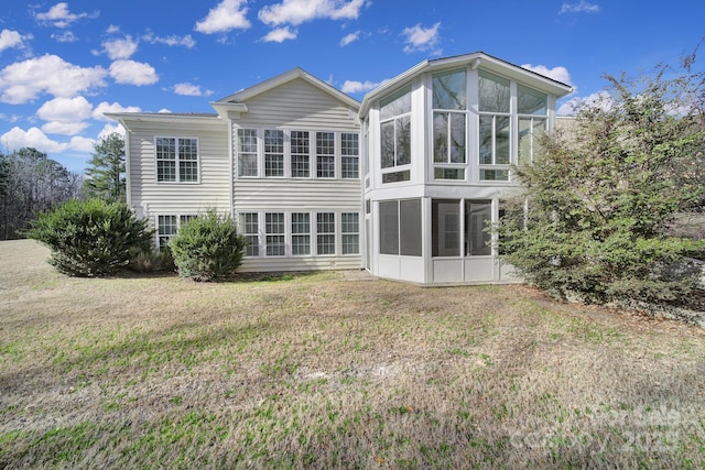 rear view of property with a sunroom and a lawn