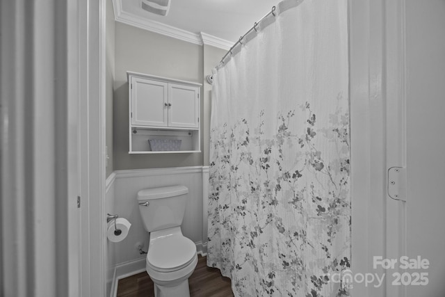 bathroom with visible vents, toilet, a wainscoted wall, ornamental molding, and wood finished floors