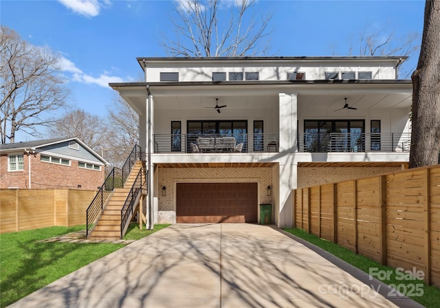 view of front of house with brick siding, ceiling fan, driveway, and stairs