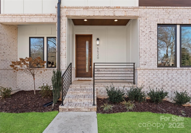 doorway to property featuring brick siding