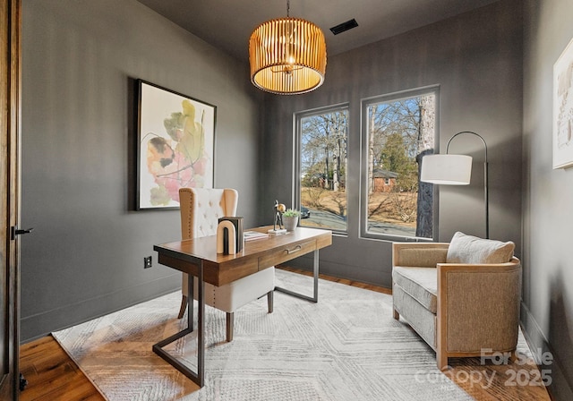office area featuring wood finished floors, visible vents, and baseboards
