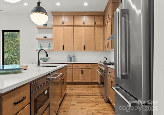 kitchen with high quality appliances, pendant lighting, light countertops, open shelves, and a sink