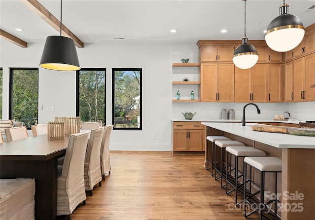 kitchen featuring light countertops, light wood-type flooring, plenty of natural light, and a kitchen breakfast bar