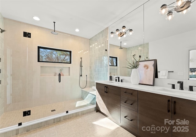 bathroom with a stall shower, a sink, recessed lighting, and double vanity