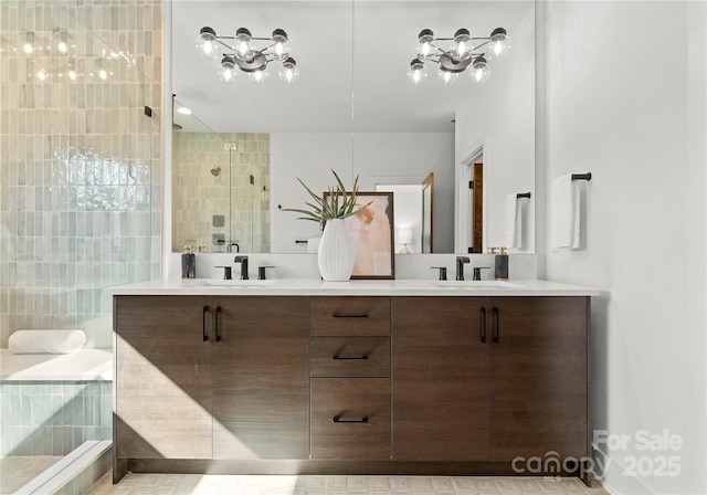 full bath featuring double vanity, a stall shower, and a sink
