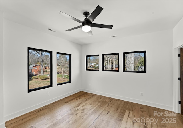unfurnished room featuring light wood-style flooring, visible vents, ceiling fan, and baseboards