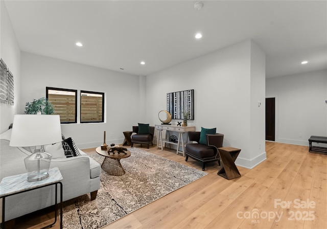 living area featuring baseboards, recessed lighting, and light wood-style floors