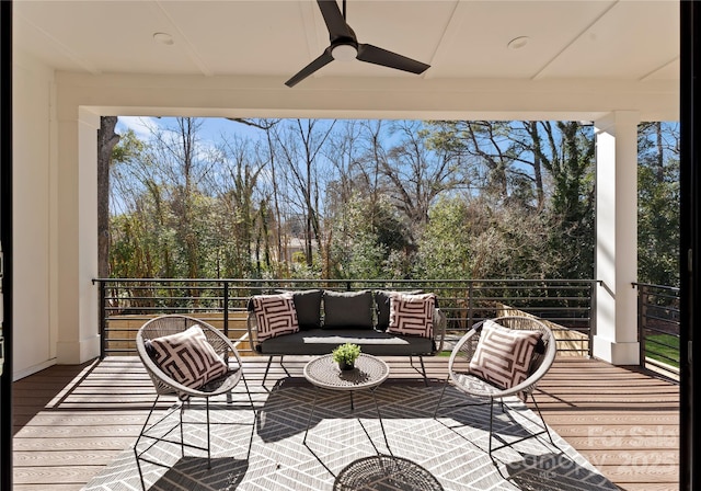 wooden terrace with outdoor lounge area and a ceiling fan