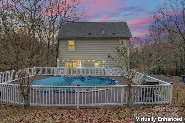 pool at dusk with a wooden deck