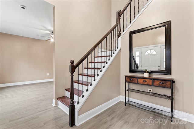 stairs featuring hardwood / wood-style flooring and ceiling fan