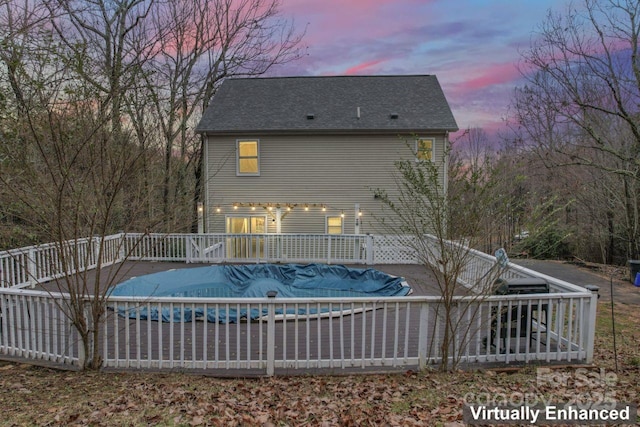 pool at dusk featuring a wooden deck