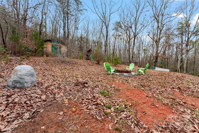 view of yard with a storage shed and a fire pit