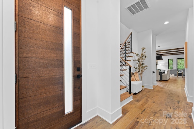 foyer entrance featuring recessed lighting, visible vents, hardwood / wood-style floors, baseboards, and stairs