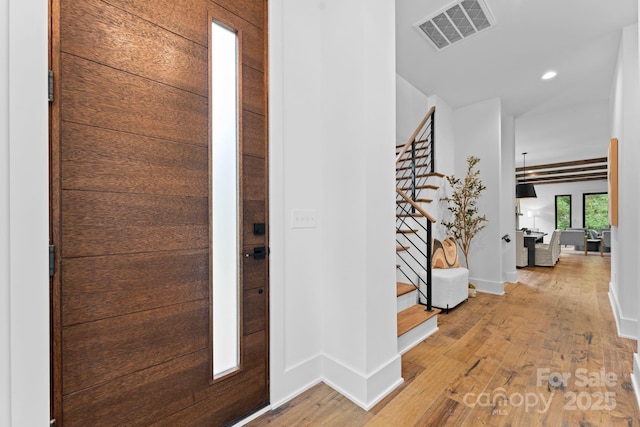 foyer with light wood-style floors, recessed lighting, visible vents, and stairway