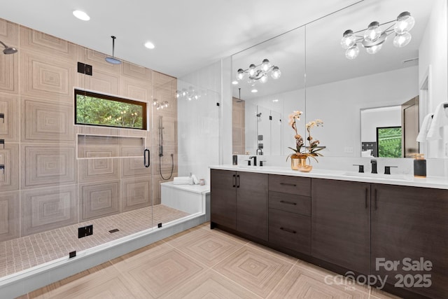 full bathroom with a shower stall, tile patterned flooring, double vanity, and a sink