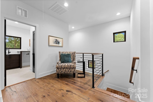living area with recessed lighting, an upstairs landing, visible vents, and light wood finished floors