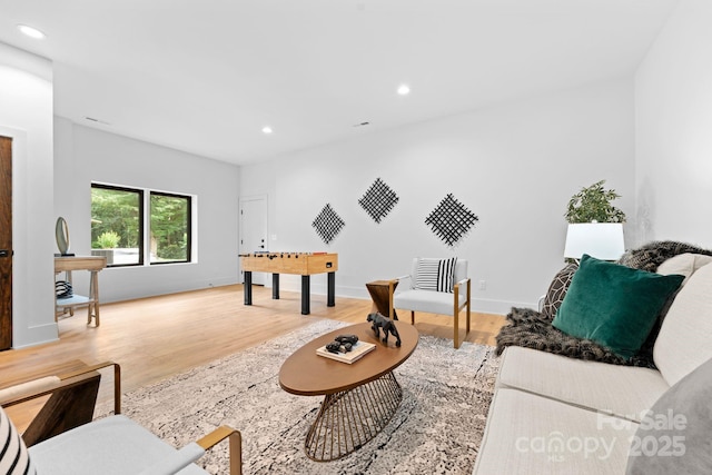 living area with recessed lighting, light wood-type flooring, and baseboards