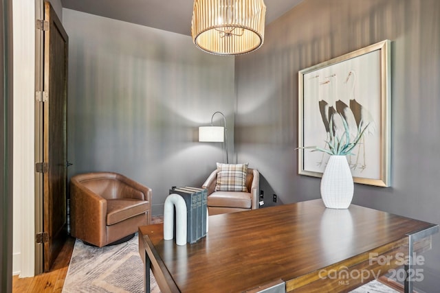 office with wood finished floors and a notable chandelier