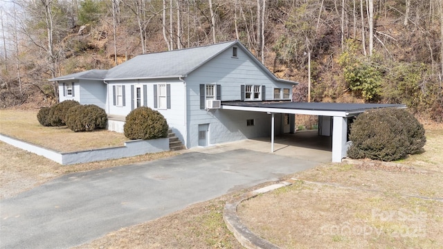 view of property exterior featuring cooling unit, a carport, and a lawn