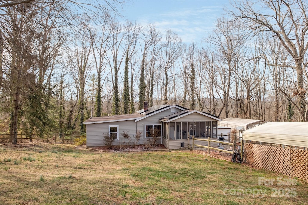 view of front of home with a front yard and a sunroom