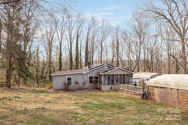 view of front of home with a front yard and a sunroom