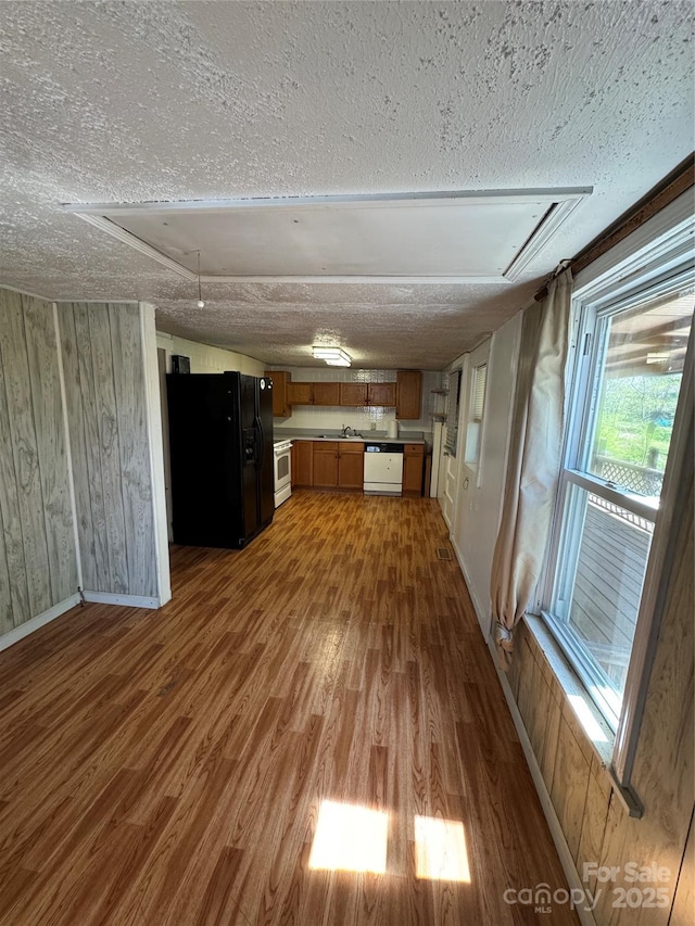 17 Jenny St, Asheville, NC 28806 - kitchen featuring black fridge, wood finished floors, white dishwasher, brown cabinetry, and a textured ceiling