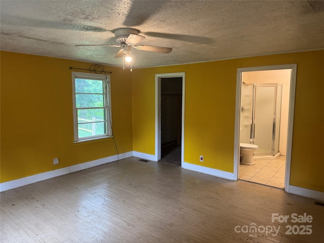 17 Jenny St, Asheville, NC 28806 - unfurnished bedroom featuring hardwood / wood-style flooring, a textured ceiling, baseboards, a spacious closet, and a closet