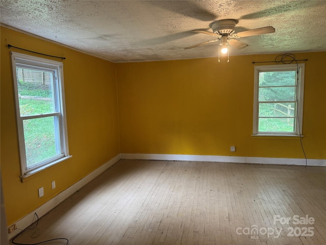 17 Jenny St, Asheville, NC 28806 - empty room featuring light wood finished floors, a textured ceiling, plenty of natural light, baseboards, and a ceiling fan