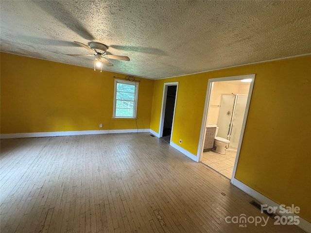 17 Jenny St, Asheville, NC 28806 - unfurnished bedroom with baseboards, wood-type flooring, connected bathroom, a textured ceiling, and a ceiling fan