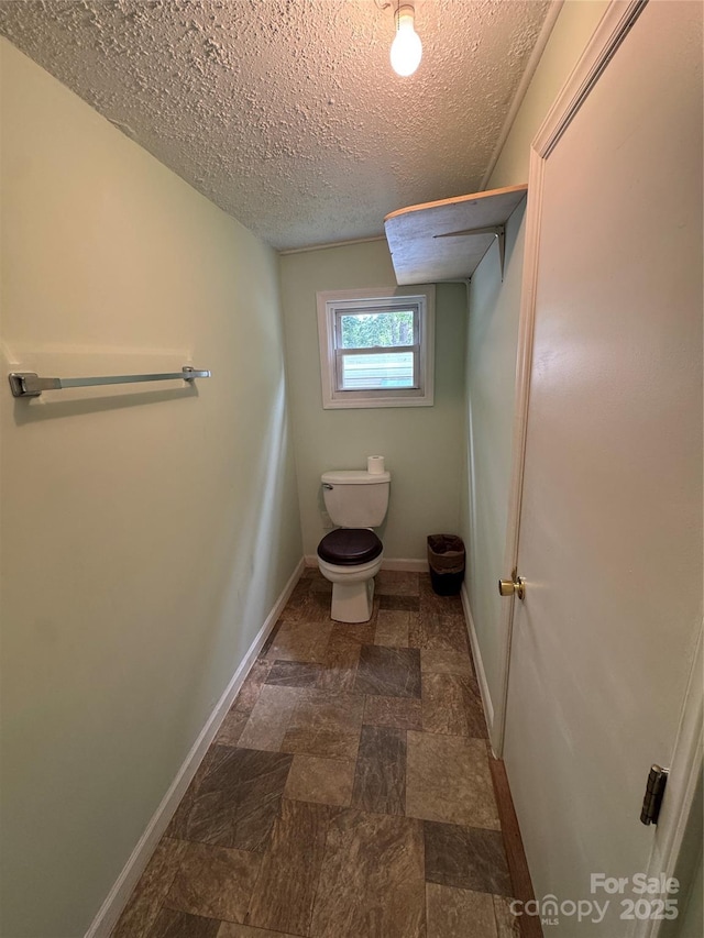 17 Jenny St, Asheville, NC 28806 - bathroom with baseboards, toilet, a textured ceiling, and stone finish flooring