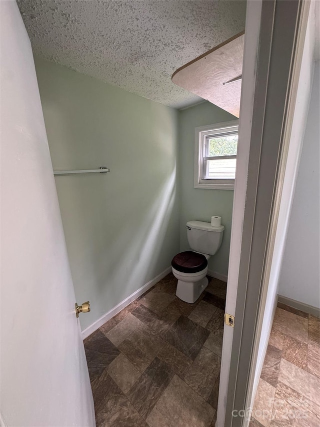 17 Jenny St, Asheville, NC 28806 - bathroom with toilet, stone finish flooring, a textured ceiling, and baseboards