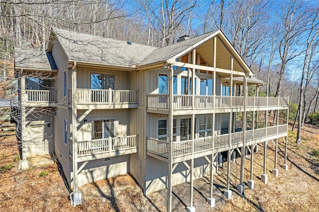 back of house featuring a shingled roof