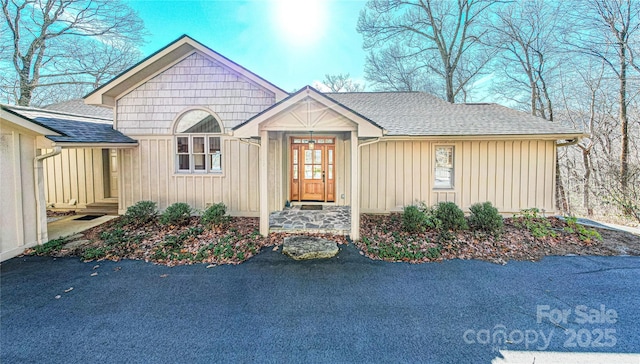 view of front of house with a shingled roof and board and batten siding